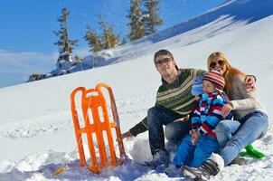 família se divertindo na neve fresca nas férias de inverno foto