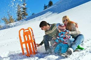 família se divertindo na neve fresca no inverno foto