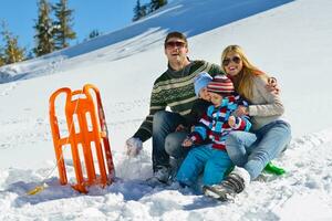 família se divertindo na neve fresca nas férias de inverno foto