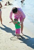 mãe e bebê na praia se divertem foto