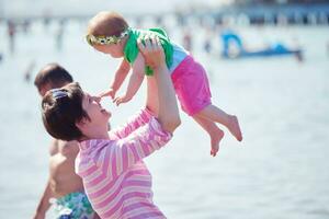 mãe e bebê na praia se divertem foto