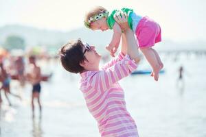 mãe e bebê na praia se divertem foto