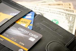 carteira com dinheiro e cartão de crédito - conceito de economia e finanças foto