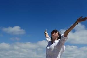 mulher jovem feliz com braços abertos para o céu foto