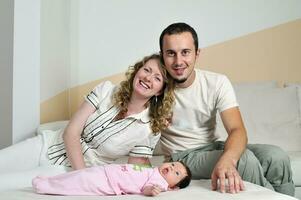 retrato interno com família jovem feliz e bebezinho fofo foto
