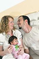 retrato interior com família jovem feliz e bebezinho fofo foto