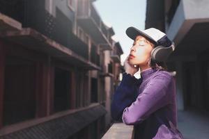 jovem asiática feliz ouvindo música com fones de ouvido foto