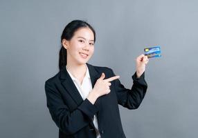 retrato de uma adorável jovem asiática mostrando cartão de crédito foto