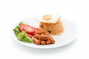 arroz frito com linguiça e ovo frito na mesa foto