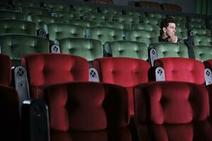 1 hispânico homem vagaroso relógios cinema sozinho, separado a partir de de outros audiências às esvaziar filme teatros, olhando às entediante filme shows, ninguém sentado dentro assentos, feliz interior entretenimento estilo de vida. foto