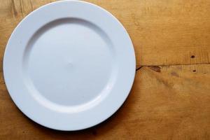 prato branco na mesa de madeira com espaço de cópia foto