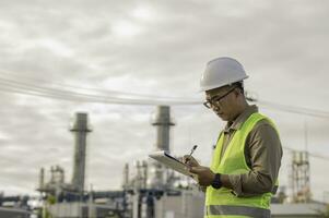 engenheiro petroquímico de homem asiático trabalhando na fábrica de indústria de refinaria de petróleo e gás, o trabalhador de pessoas engenheiro de controle de trabalho na fabricação de indústria de energia de usina foto