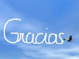 obrigada, espanhol obrigado você mensagem, a partir de biplano fumaça - 3d render foto