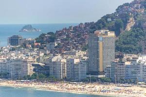 praia de copacabana com favela de pavões ao fundo