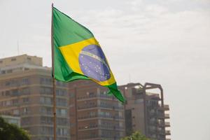 bandeira do brasil ao ar livre com edifícios ao fundo