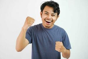 jovem bonito ásia homem vestindo casual em pé sobre isolado branco fundo muito feliz e animado fazendo vencedora gesto com braços criado, sorridente e gritando para sucesso. celebração foto