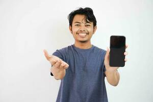 feliz sorridente ásia jovem homem mostrando Móvel telefone dentro de outros mão aberto isolado em branco fundo foto