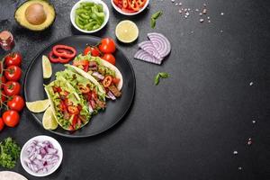 tacos mexicanos com carne, tomate, abacate, cebola e molho de salsa foto
