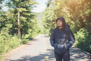 homem alpinista andando na estrada rural. conceito de turismo de férias. foto