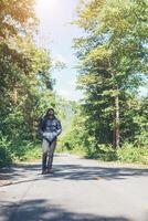 homem alpinista andando na estrada rural. conceito de turismo de férias. foto