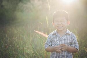 menino asiático feliz brincando ao ar livre. bonito asiático. menino em campo. foto