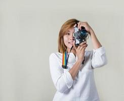 bela jovem fotógrafa segurando uma câmera retro foto