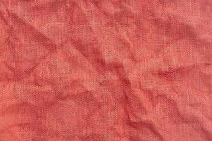 tecido de serapilheira vermelho com textura de fundo de rugas. quadro completo