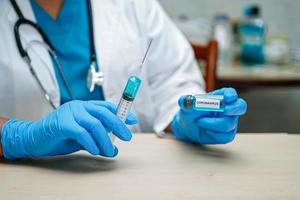 médico segurando seringa com vacina coronavírus covid-19 foto