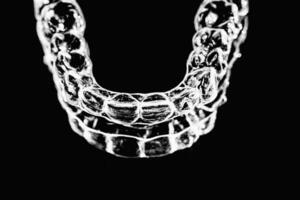 invisível dental dentes colchetes dente alinhadores em Preto fundo. plástico suspensórios odontologia retentores para endireitar dentes. foto