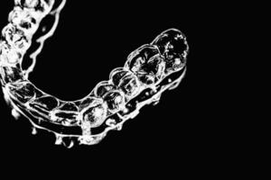 invisível dental dentes colchetes dente alinhadores em Preto fundo. plástico suspensórios odontologia retentores para endireitar dentes. foto
