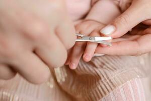 mãe cortes unhas para pequeno bebê foto