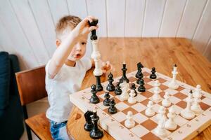 criança jogando xadrez às casa às a mesa foto