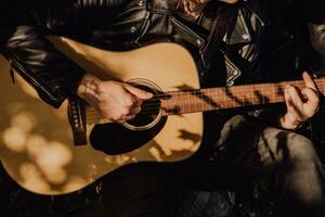 homem jogando guitarra dentro natureza em uma ensolarado dia foto