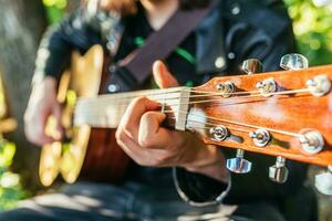 homem jogando guitarra dentro natureza em uma ensolarado dia foto