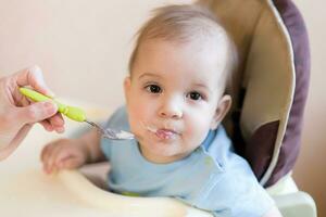 mãe dá bebê Comida a partir de uma colher foto