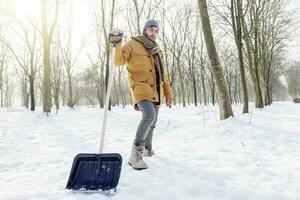 jovem homem pá neve perto uma pequeno madeira foto