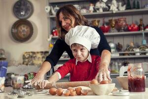 mãe ajudando dela filho preparar doce Comida foto