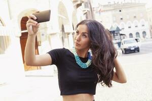 bonita jovem menina turista leva uma selfie dentro a velho Cidade foto
