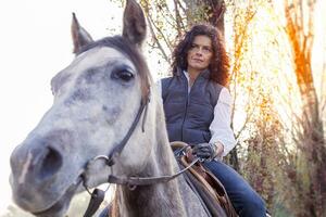 amazona passeios dele cavalo para a país estradas dentro outono foto