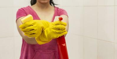 jovem mulher equipado com spray garrafa e esponja. serviço de limpeza e limpeza conceito. mulheres preparando para limpar \ limpo acima banho foto