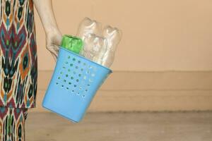 plástico poluição. fêmea coletado plástico garrafas e segurando reciclando bin. livre espaço foto