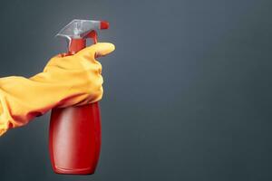 fêmea mão dentro borracha luvas segurando desinfetante spray foto