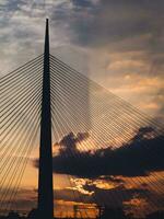 grande suspensão ponte torre às pôr do sol - raios solares através a nuvens dentro a fundo foto