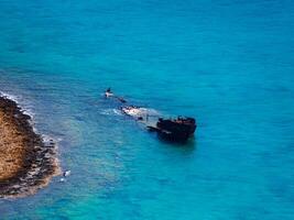 velho afundado e abandonado navio perto Rocha costa foto