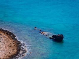 velho afundado navio perto a rochoso costa - lindo azul água foto