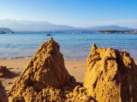 quebrado areia castelos em uma esvaziar areia de praia foto