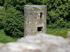 velho céltico castelo torre entre a árvores com borrado pedra dentro a frente, blarney castelo dentro Irlanda, velho antigo céltico fortaleza foto