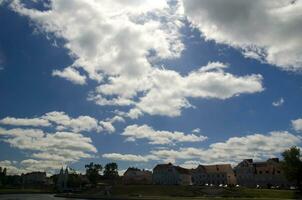 branco nuvens dentro profundo azul verão céu, sobre lindo casas foto