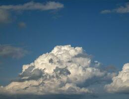 branco e cinzento cumulus nuvens fundo sobre a azul verão céu fundo foto