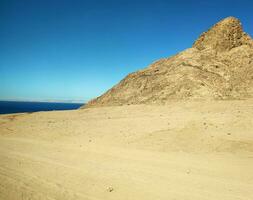 deserto terra com montanhas e mar foto